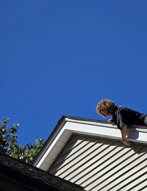 Sarah Driscoll of Magnum Pest Control inspecting for rodent entry points in a home fascia boar Sarah Driscoll of Magnum Pest Control inspecting for rodent entry points in a home fascia board